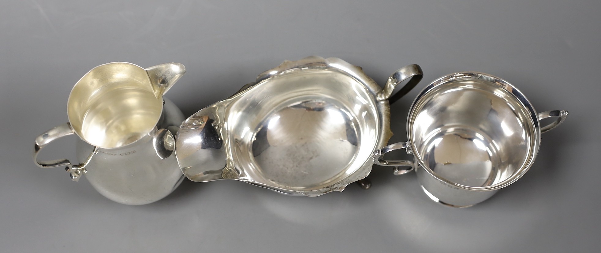 A small silver jug, Birmingham 1946 by Thomas Ducrow & Sons, together with a silver two handled cup, London 1973 by Tessiers Ltd and a silver sauceboat, 12oz.